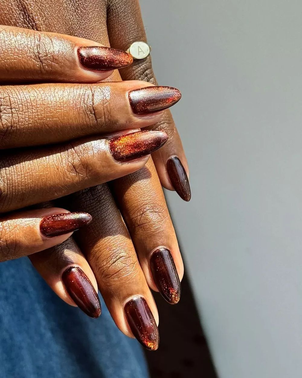 Copper glitter cat eye almond nails on dark skin, warm copper magnetic glitter set
