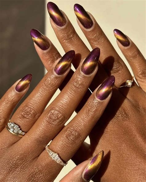 Purple gold duochrome cat eye almond nails on dark skin, shifting magnetic finish