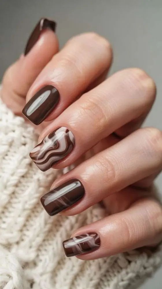 Chocolate short nails with a white swirl accent, brown set with one marble swirl nail