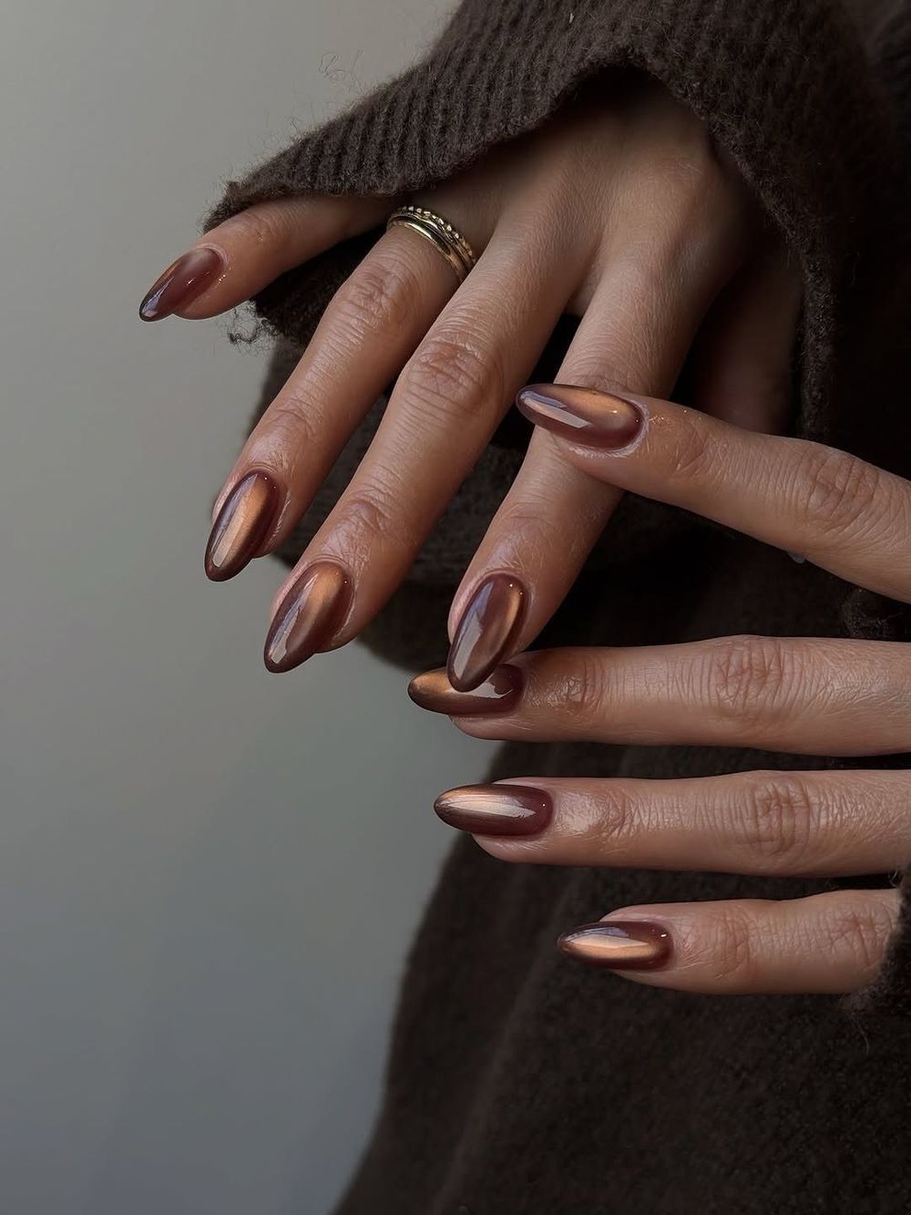 Coffee chrome almond nails in a brown knit, warm brown chrome with a sweater sleeve