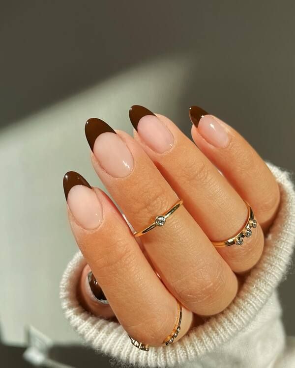 Nude almond nails with chocolate French tips, bare base with brown tips