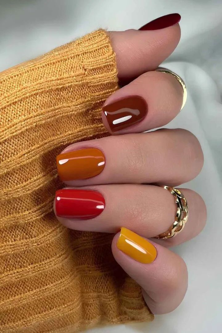 Fall rainbow almond mix in a mustard knit, burgundy, rust, red, orange and mustard nails
