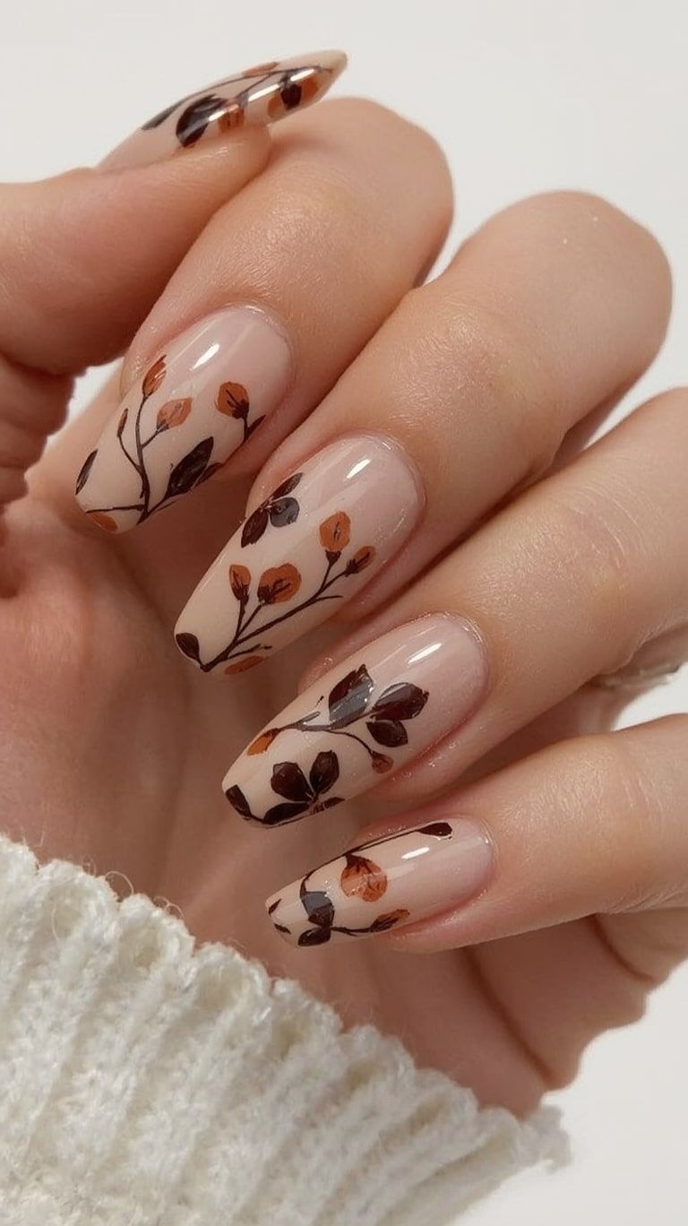 Nude almond nails with hand painted brown leaf and branch art, cream knit sleeve