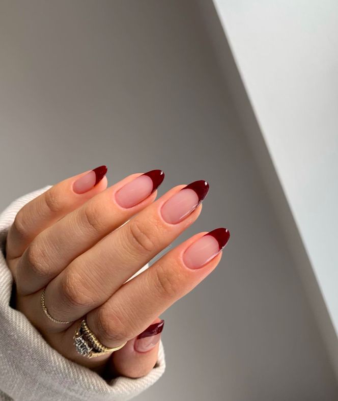Nude almond nails with deep burgundy French tips, classic fall French manicure