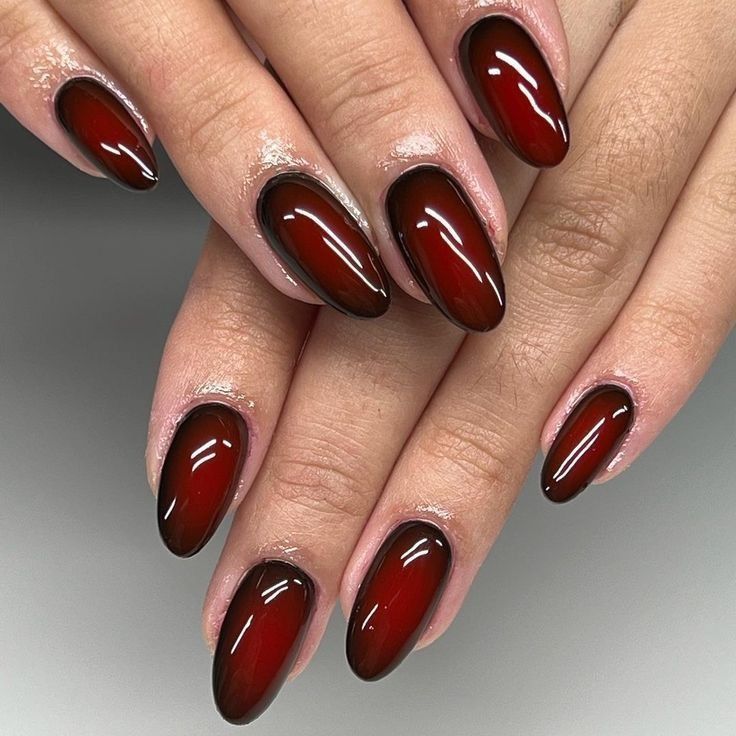 Black cherry aura almond nails with a dark red jelly center fading to near black edges