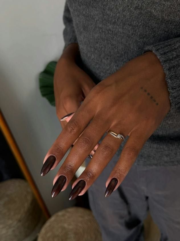 Dark chocolate almond nails on dark skin in a grey sweater, glossy espresso brown gel