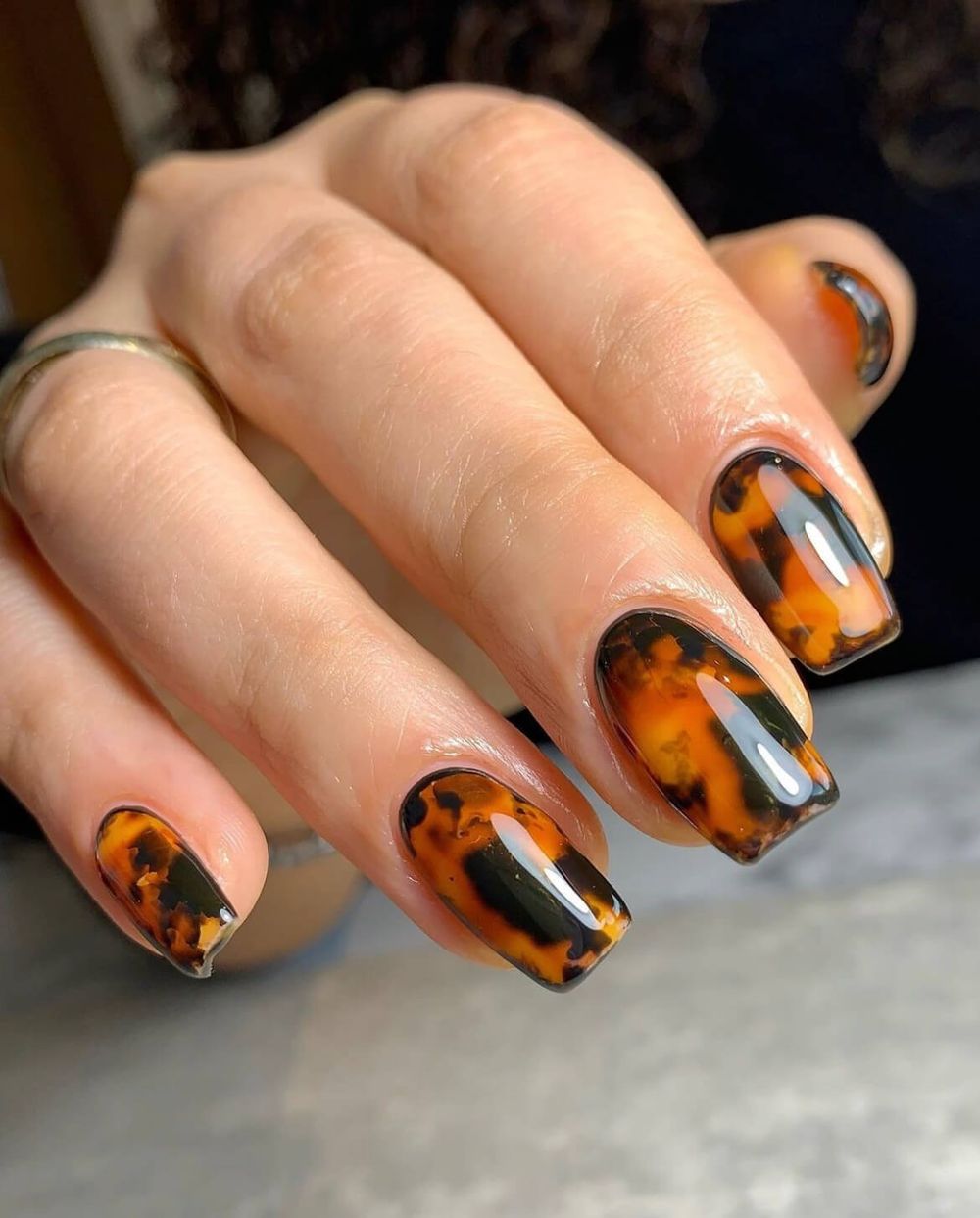 Tortoiseshell coffin nails close up with bold amber and black marbling and a high gloss finish