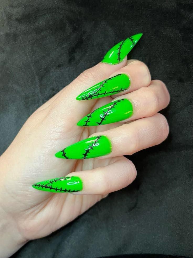 Neon green stiletto nails with black Frankenstein stitch lines, glossy finish