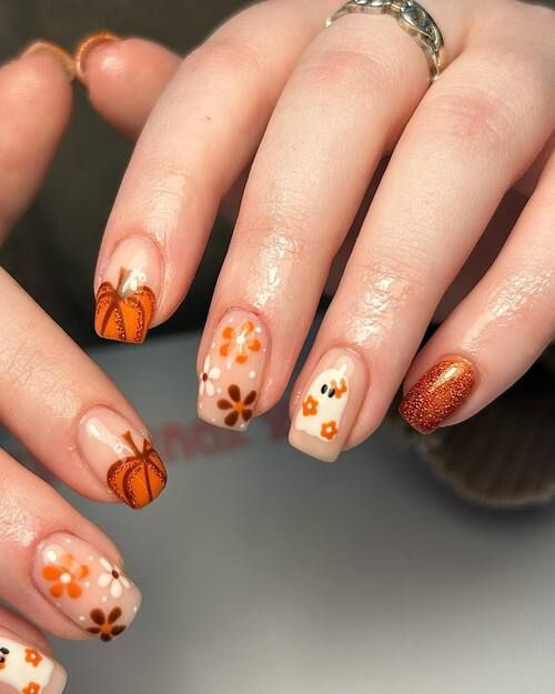 Nude short nails with tiny pumpkin and flower art and one copper glitter accent nail