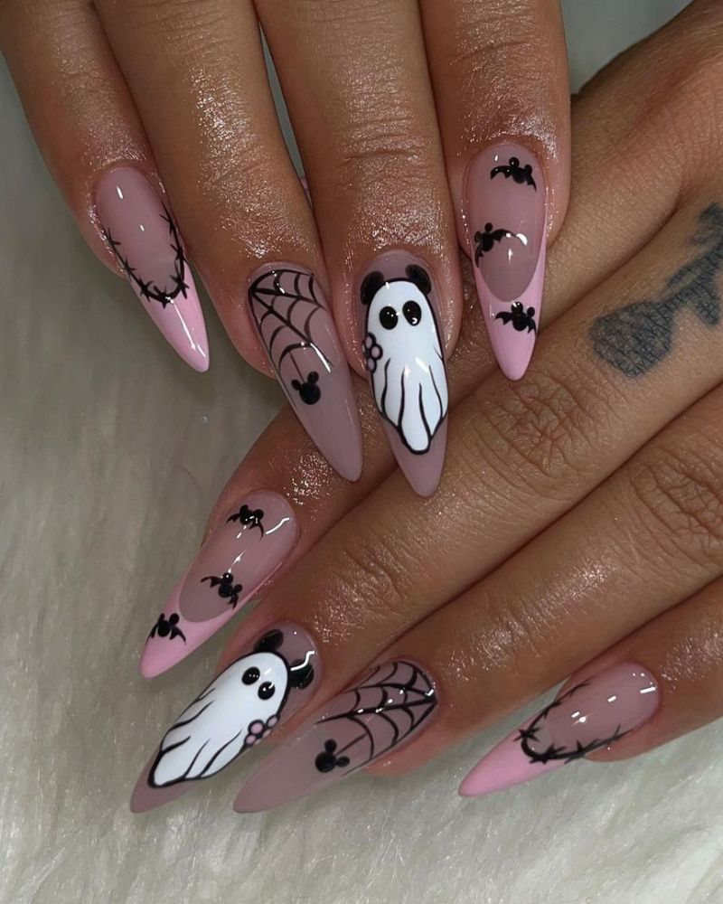 Pink almond nails with white ghost art, tiny bats and spiderweb details on a sheer base