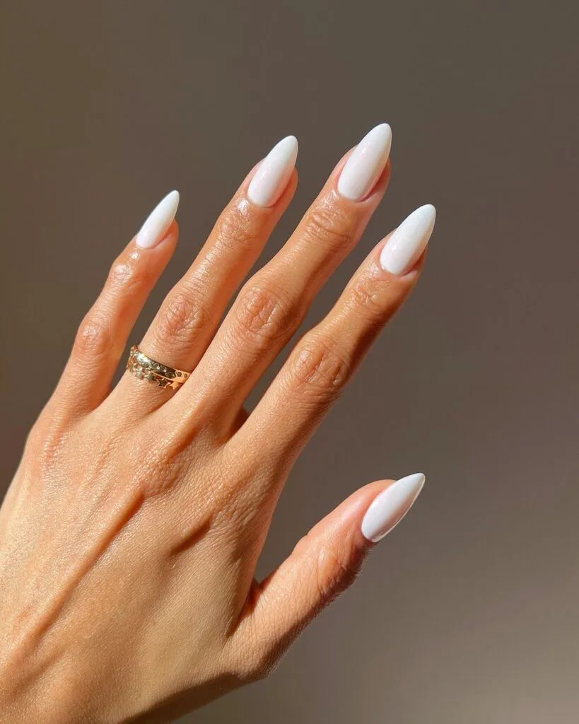 Glossy white almond nails on brown skin, clean glossy white set