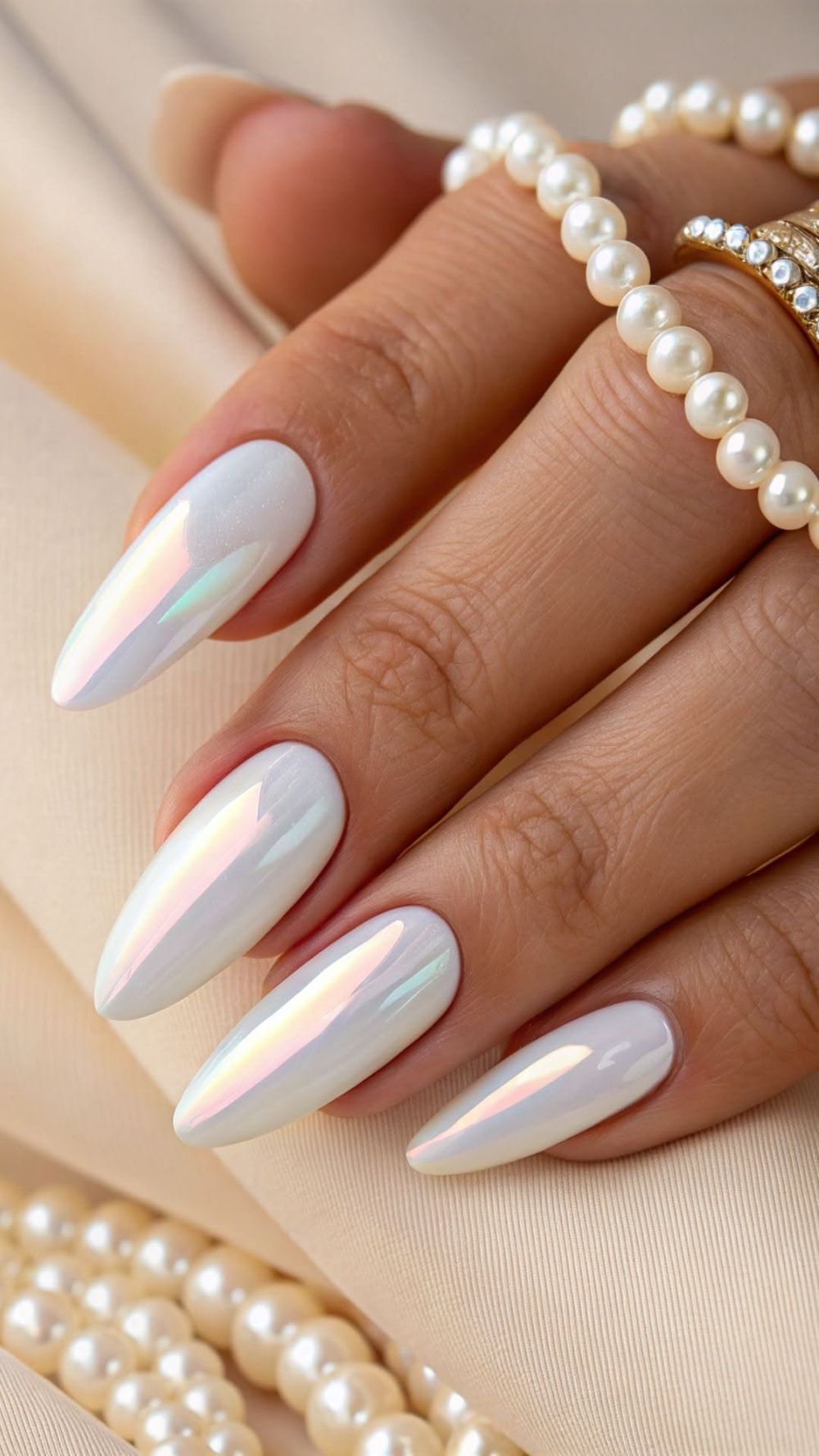 Iridescent white chrome almond nails with pearls, glowing white set with a pearl bracelet