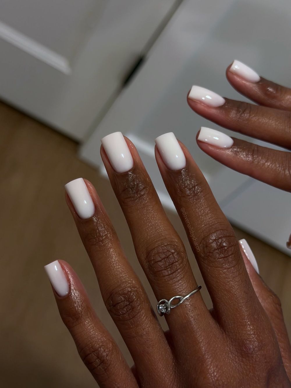 Milky white almond nails on dark skin shown on two hands, matching white glow set