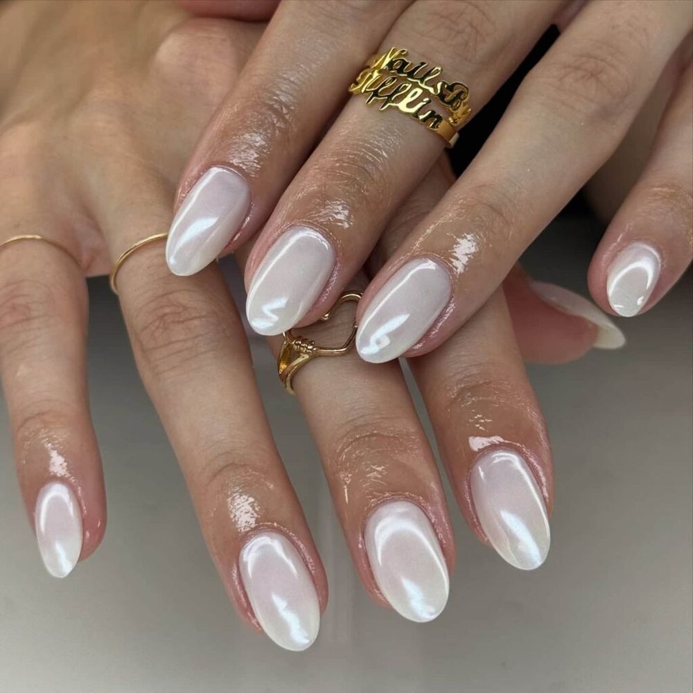 Milky white chrome almond nails with gold jewelry, glazed white with layered gold
