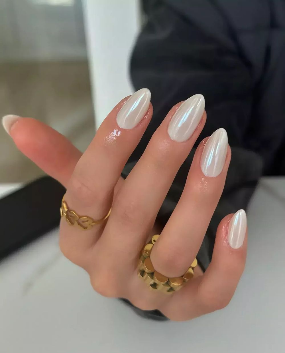 Milky white chrome almond nails with gold rings, glazed white set with gold jewelry