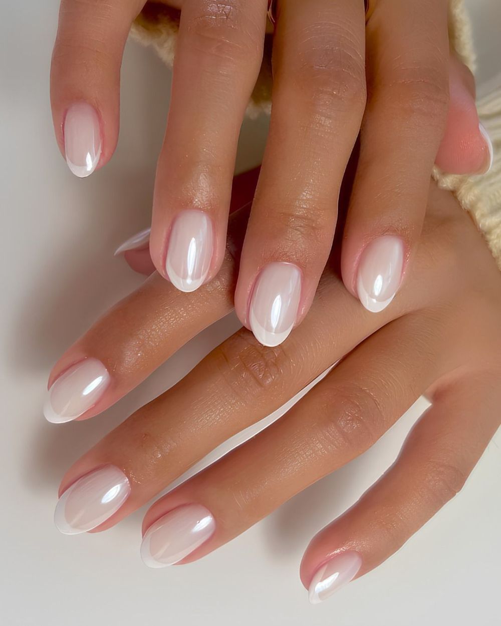 Sheer milky almond nails on two hands, barely there white glow set