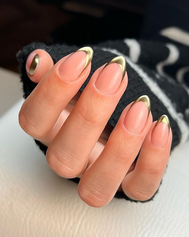 Gold chrome French short oval nails in a knit, metallic gold tips at short length
