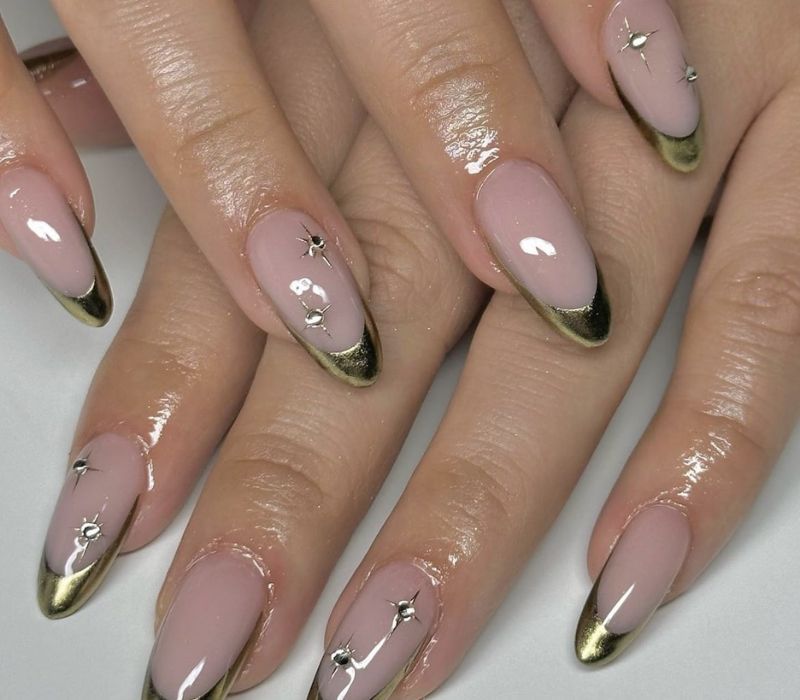 Gold French almond nails with star gems, gold tips with tiny star crystals