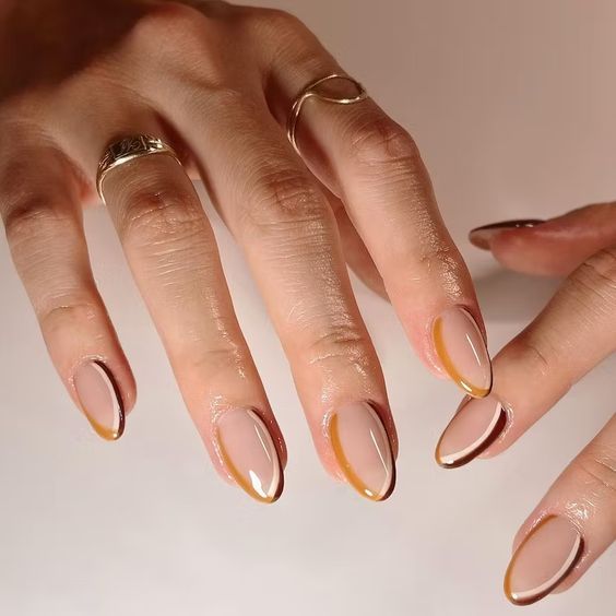 Gold outline French almond nails on brown skin, nude base with a fine gold tip outline