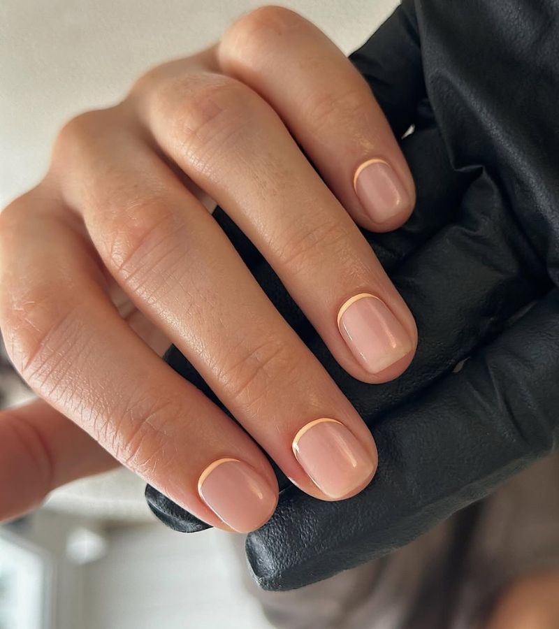 Nude micro French short nails in a salon, bare nails with hair thin nude tips