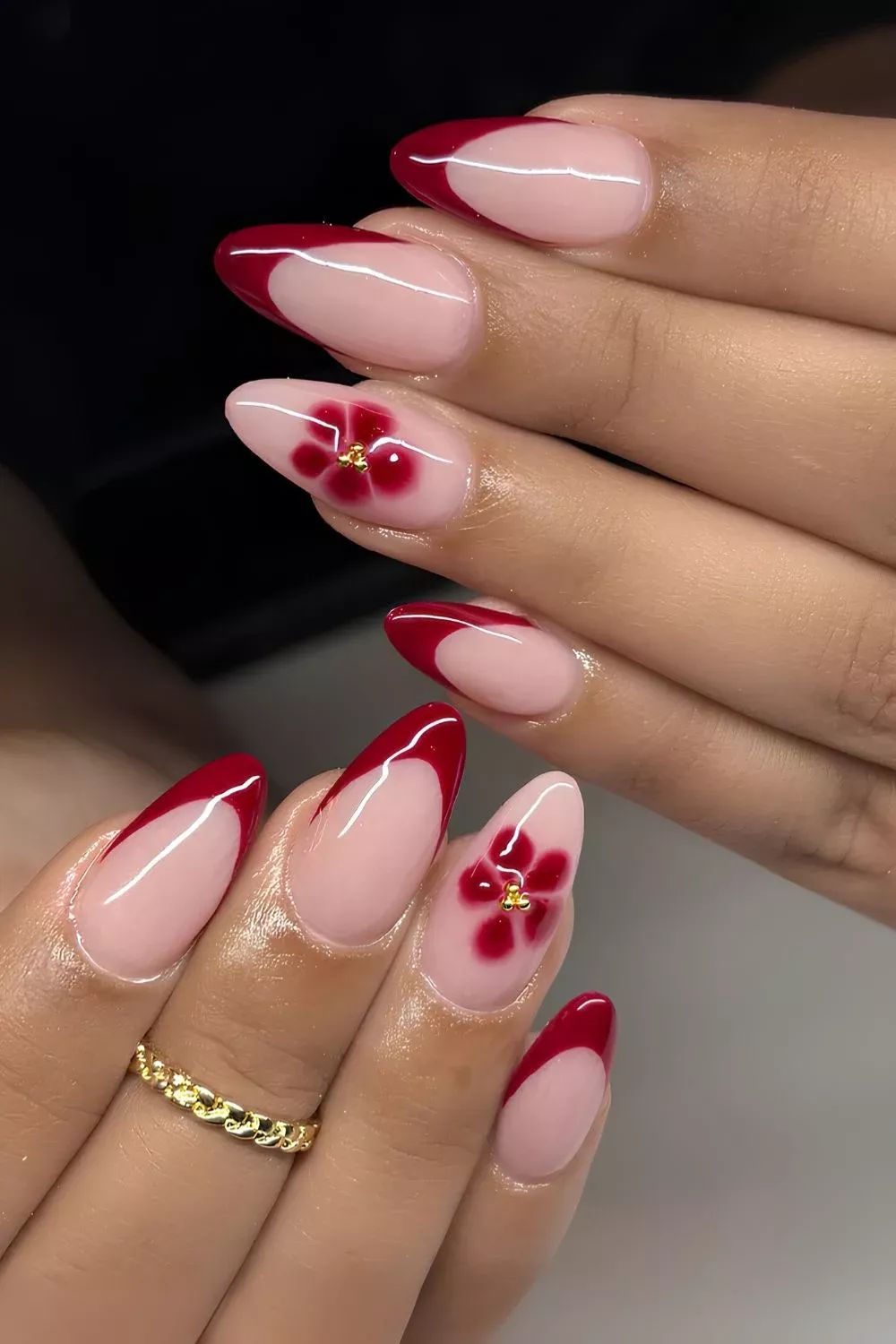 Red French almond nails with flower art, bright red tips with floral accents