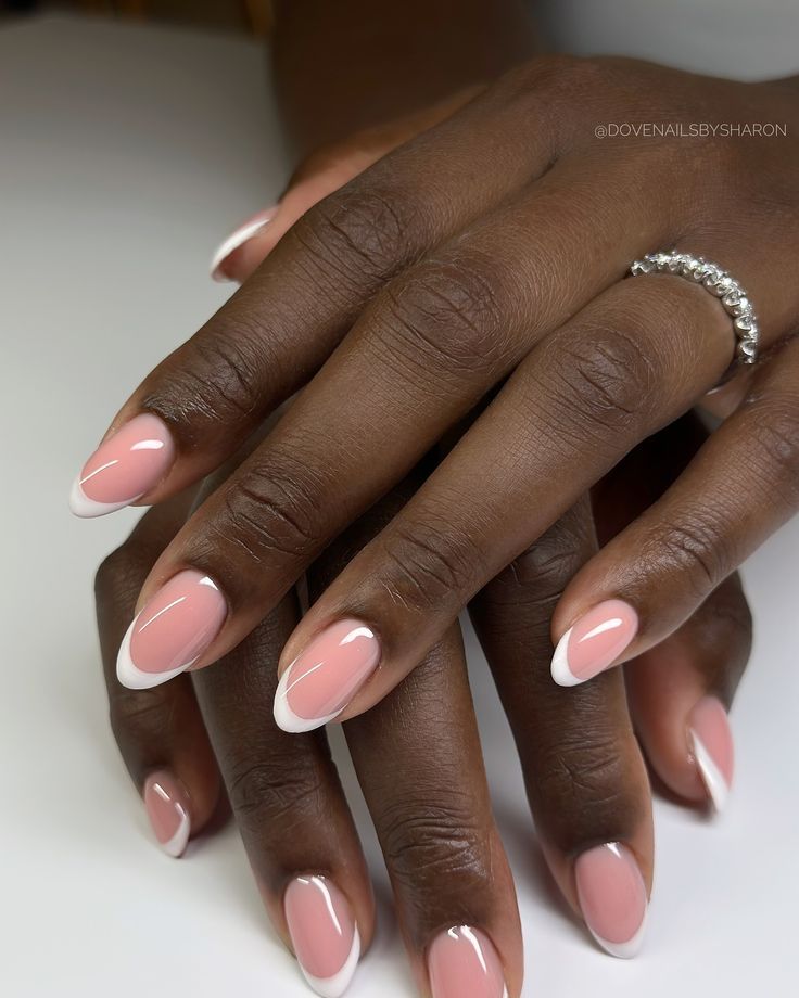 White French almond nails on dark skin, classic white tips on an almond