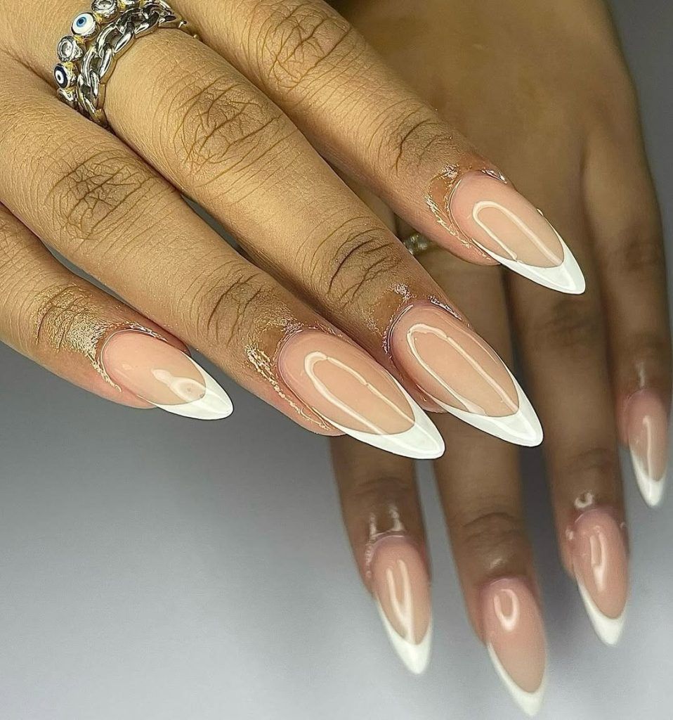 White French stiletto nails on brown skin, crisp classic white tips at length