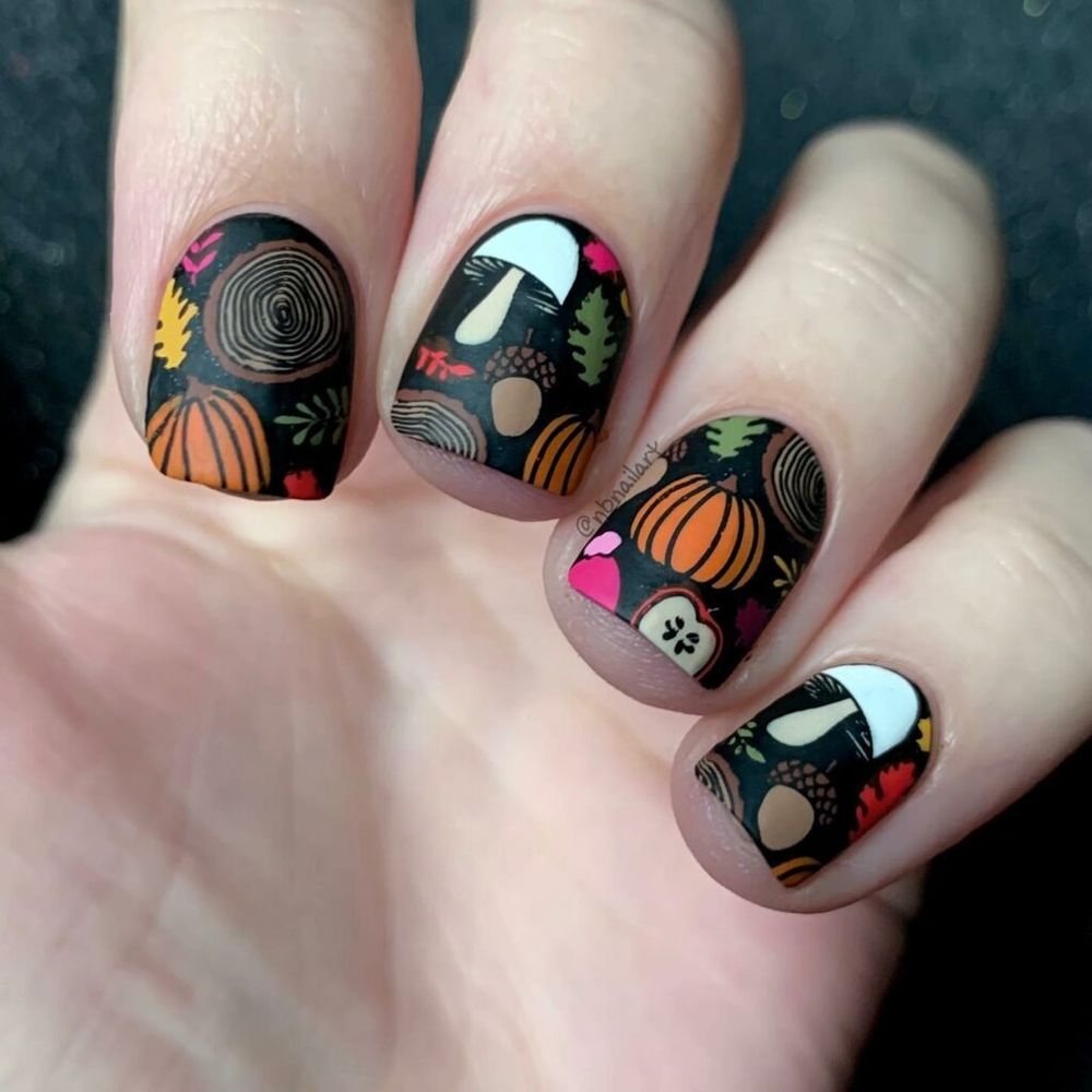 Halloween pumpkin art short oval nails, black base with orange pumpkins and fall motifs