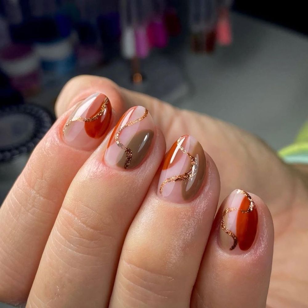 Rust and gold art short oval nails, burnt orange with gold swirl details
