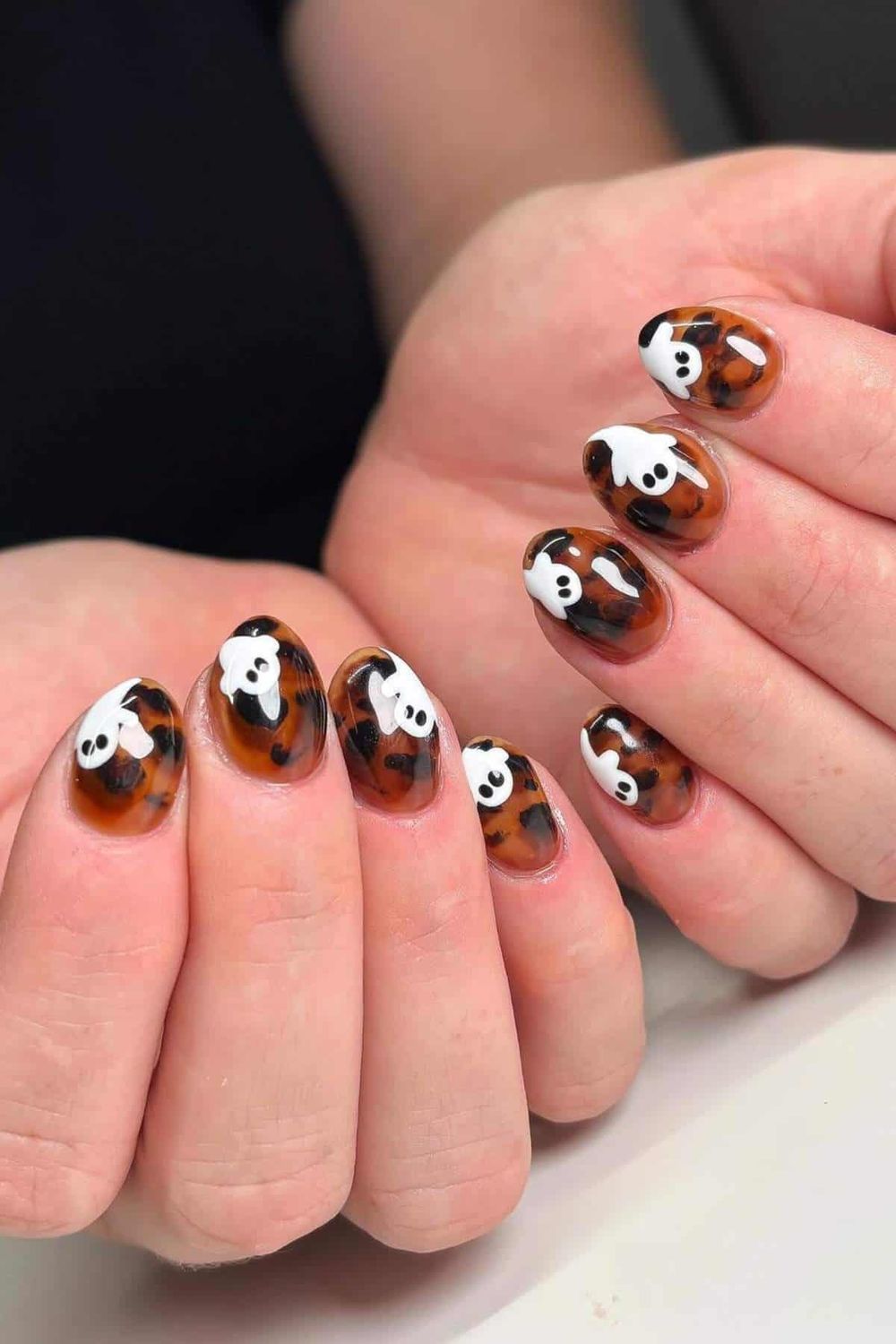 Tortoise and skull art short oval nails, tortoiseshell with tiny white ghost faces