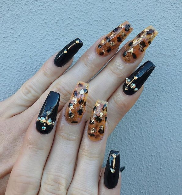 Black and tortoiseshell almond nails with gems, black gloss and amber marble with crystals