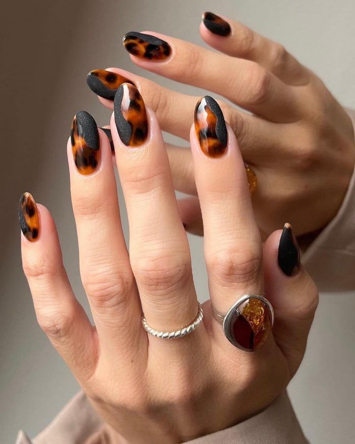 Black and tortoiseshell almond nails, black gloss alternating with amber marble