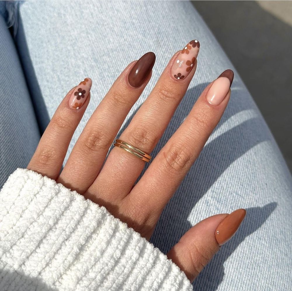 Brown and nude almond nails with a tortoiseshell accent, mixed browns with one marble nail