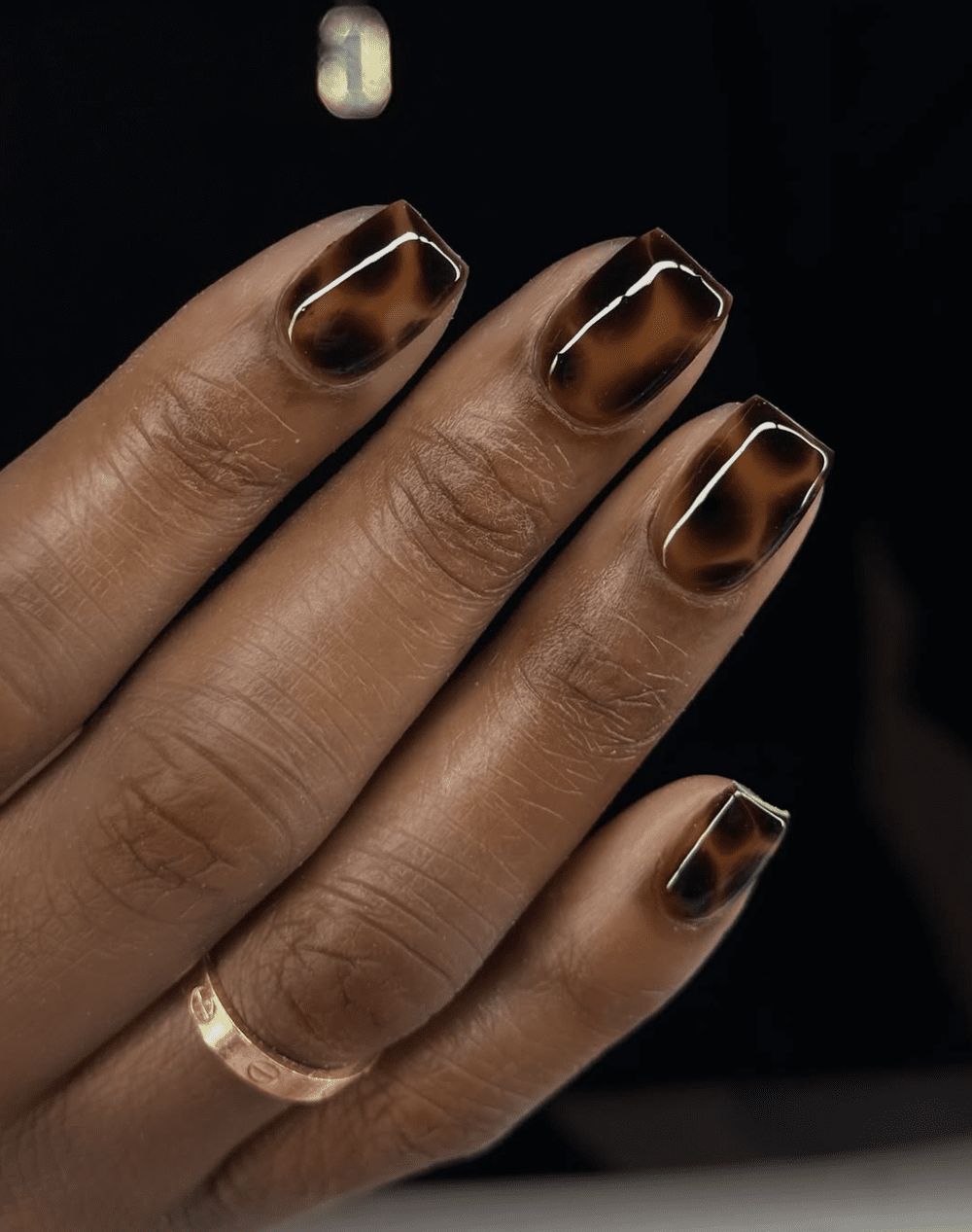 Dark tortoiseshell square nails on dark skin, deep amber marble square set
