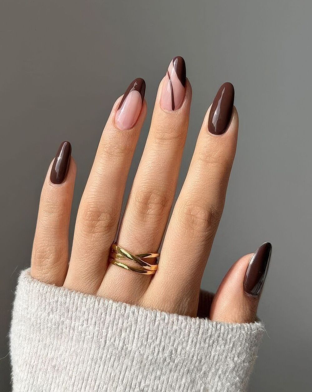 Nude almond nails with a chocolate swirl, sheer nude with one chocolate marble accent
