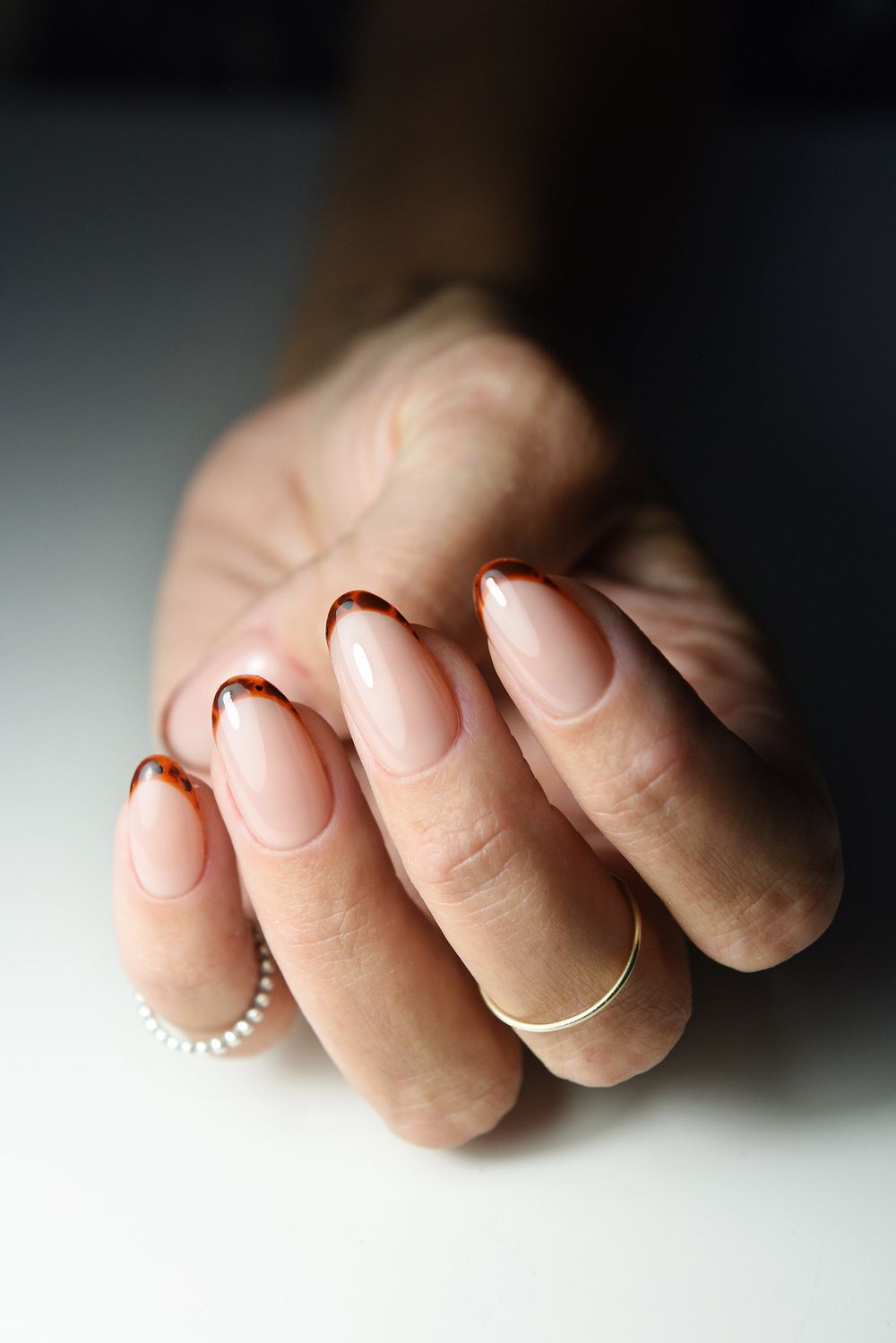 Nude short nails with tortoiseshell tips, bare base with amber tortoise edges