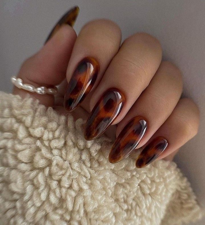 Tortoiseshell almond nails in a cream knit, amber marble with a cozy sweater sleeve