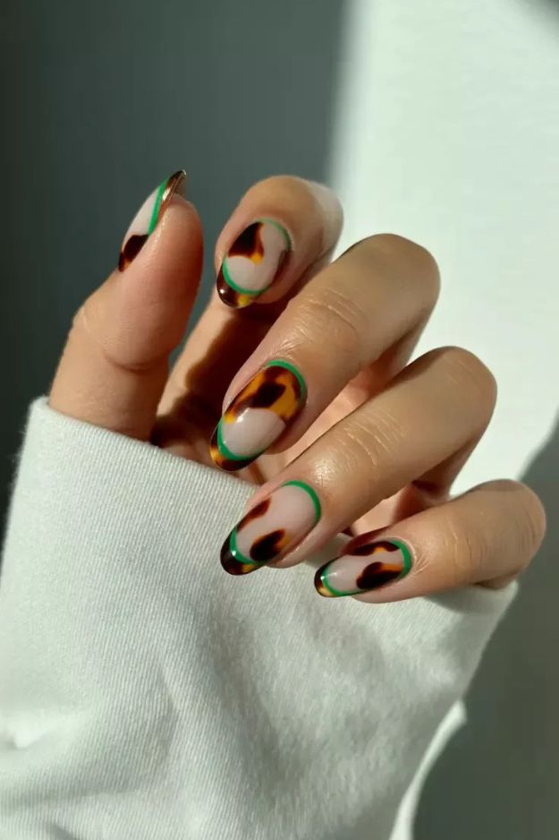 Tortoiseshell art almond nails with a green outline, amber marble framed in green