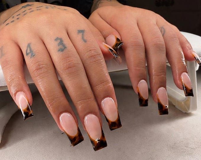 Tortoiseshell French square nails with tattooed hands, nude base with tortoise tips on a square