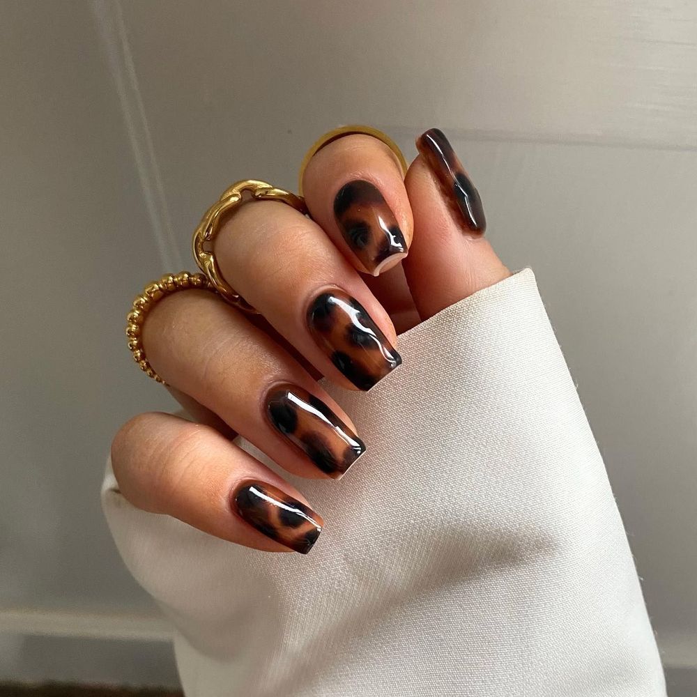 Tortoiseshell short square nails in a cuff, amber marble short set with a sweater cuff
