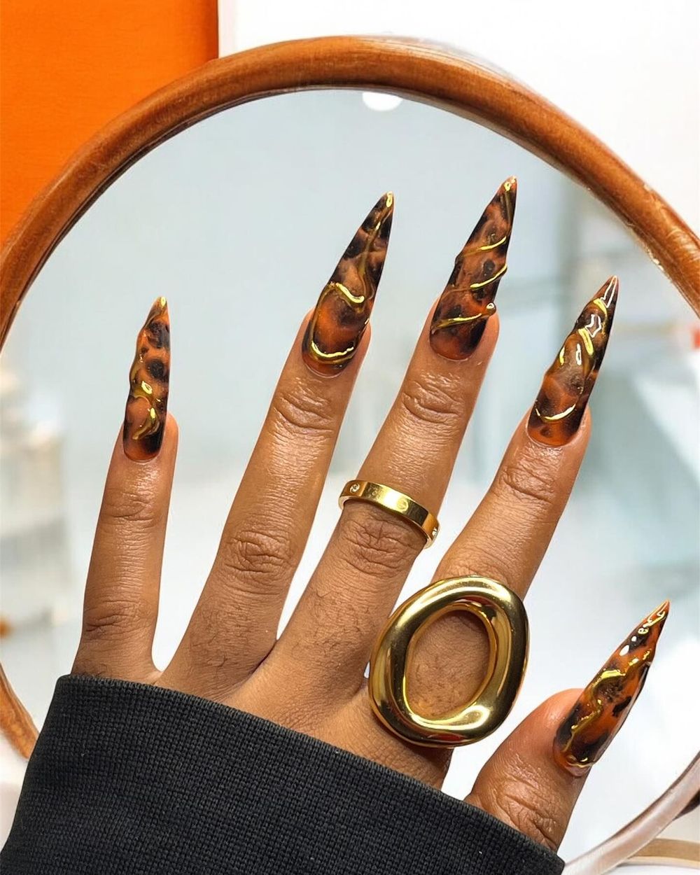 Tortoiseshell stiletto nails with gold swirls, amber marble with metallic gold lines